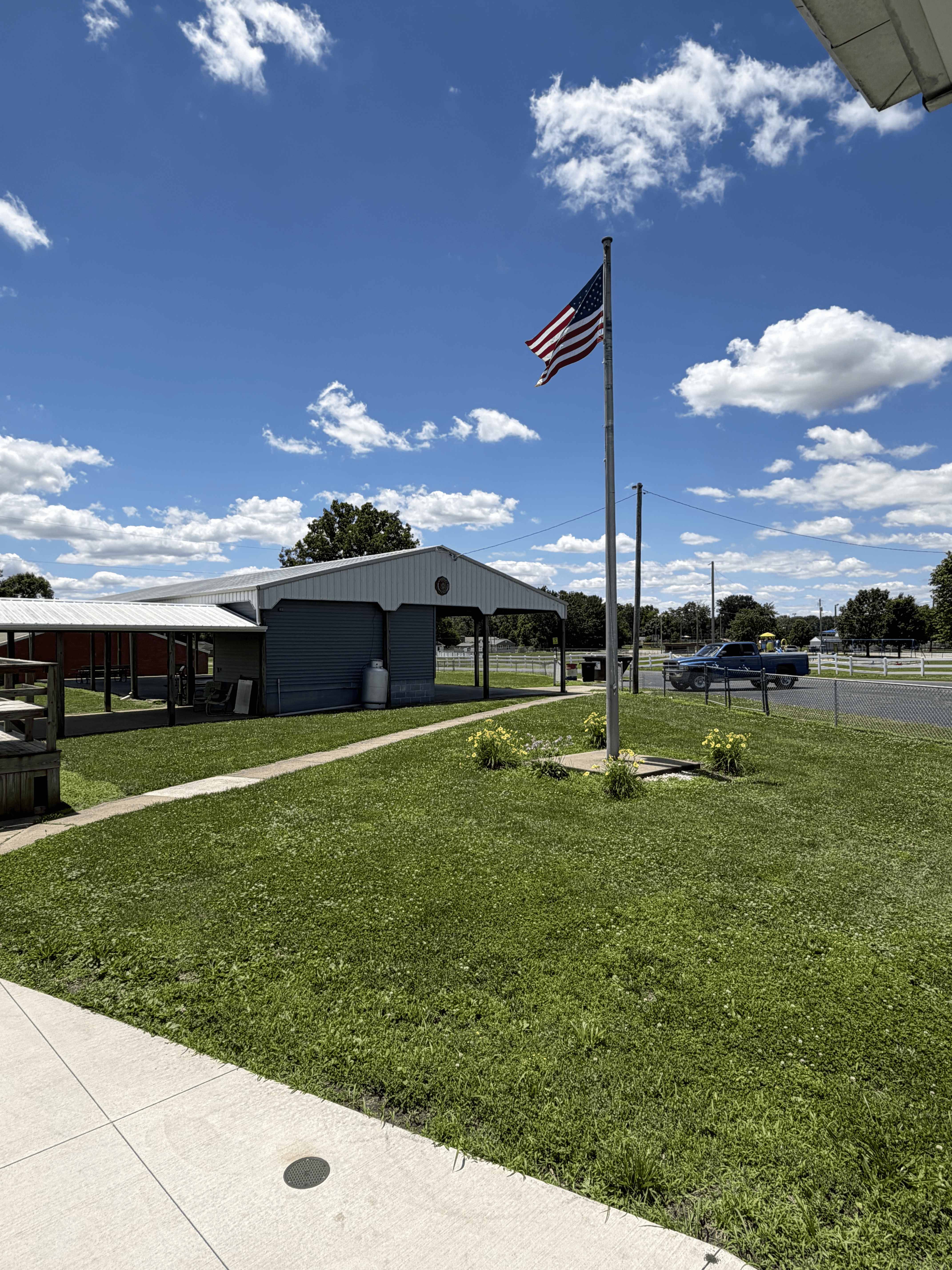 Covered pavilion and open grounds at American Legion Post #211 with the American flag flying